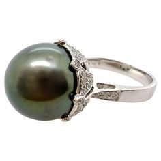 This elegant 13.55 mm black Tahitian pearl is set in a custom diamond setting that completely exhibits the beauty of the pearl! The undercarriage has the pavé diamonds that is beautifully arranged. A fabulous piece for any occasion! Size: 6.5 / can be sized Stone: Black Tahitian Pear 13.55 mm Diamonds: 0.56 ct total weight Metal: 18k White gold Tahitian Pearl Ring, Tahitian Black Pearls, Diamond Settings, Tahitian Pearls, The Pearl, Tahiti, Pearl Ring, Solitaire Ring, Pave Diamonds