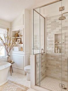 a bath room with a toilet a tub and a shower stall next to a window