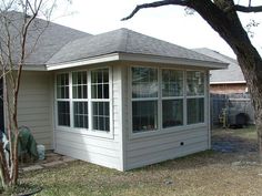 a small house with a large tree in the yard