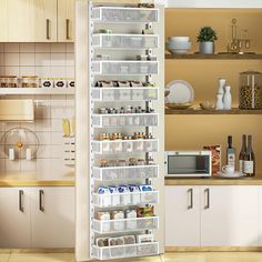 a kitchen with white cabinets and shelves filled with food