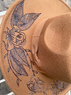 Celebrate your inner country girl with this unique Custom Rancher Hat. Hand burned flowers give it an eye-catching flair, perfect for a fashion-forward look. Show off your brown-eyed girl style in this one-of-a-kind hat. hand burned hat with floral details Brown Flat Brim Fedora For Spring, Spring Brown Flat Brim Fedora, Trendy Brown Felt Hat With Flat Brim, Brown Short Brim Fedora For Spring, Bohemian Brown Fedora With Curved Brim, Brown Fedora Felt Hat For Spring, Brown Fedora With Curved Brim For Festivals, Brown Curved Brim Fedora For Festivals, Trendy Brown Fedora For Rodeo