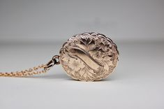 "9k Repousse Floral Foliate Oval Locket, Rosy Gold, Hand Chased, Glass Cover, 9ct Front & Back, Canadian, Aesthetic, Antique, circa 1890, 4.82 grams. This richly detailed antique locket from the Aesthetic Movement is crafted in 9ct gold.  Flowing plumes of floral foliate is etched on the front, surrounding a blank banner that has not been monogrammed.  The reverse is covered in richly etched leaves.  A unique scalloped border adds exquisite detail to this locket.  What a lovely representation of Antique Rose Gold Jewelry For Ceremonial Occasions, Victorian Oval Rose Gold Jewelry, Victorian Rose Gold Oval Jewelry, Canadian Aesthetic, Aesthetic Antique, Blank Banner, Antique Locket, Oval Locket, Aesthetic Movement