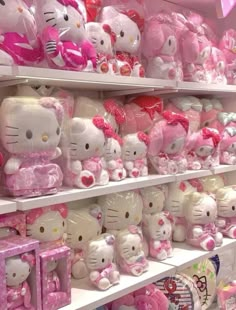 many hello kitty stuffed animals are on display in a toy store with pink and white colors