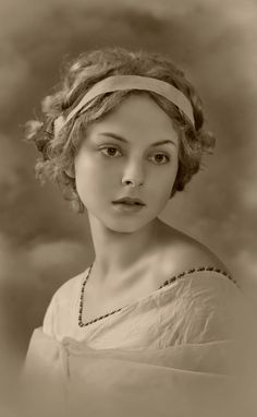 an old photo of a woman wearing a headband