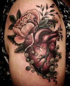 a heart tattoo with flowers on it