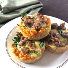 three muffins with meat and cheese on a plate