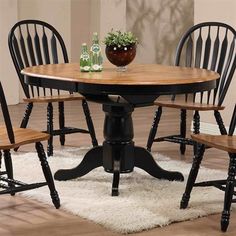 a dining room table with four chairs and a potted plant on top of it