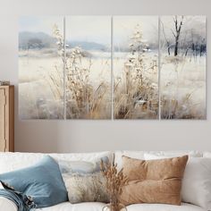 a living room scene with three paintings on the wall and one painting on the couch