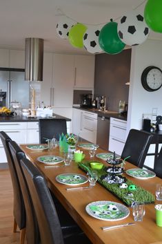 the table is set with soccer themed plates and place settings for people to sit at