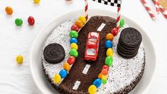 a birthday cake decorated to look like a race car with cookies and candy on the side