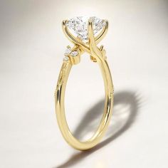 a yellow gold engagement ring with three stones on the side and an oval diamond center