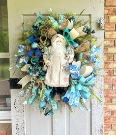 a wreath is hanging on the front door of a house with a santa claus figure