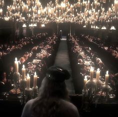 a large room filled with lots of tables covered in candles