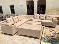 a large sectional couch sitting on top of a cement floor in front of a building