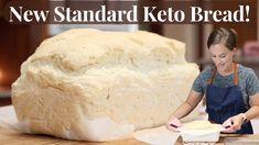 a woman in an apron making bread on top of a wooden table with the words new standard keto bread