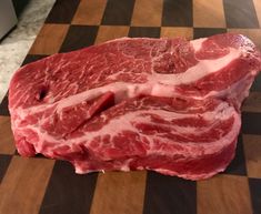 raw meat sitting on top of a wooden cutting board