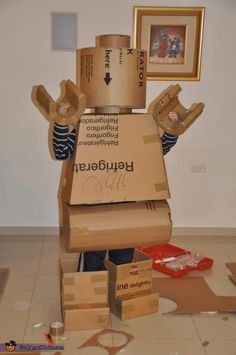 a cardboard robot made to look like it is moving out of the box with his hands