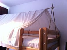 a wooden bunk bed with a white sheet over it