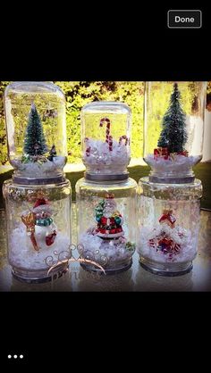 four snow globes with christmas decorations in them