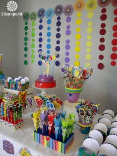 a table topped with lots of cupcakes and candy bar decorations on top of it