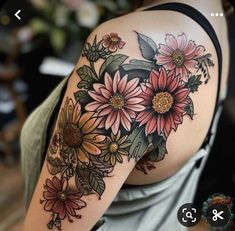 a woman's arm with flowers and leaves tattooed on the back of her shoulder