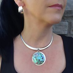 Add mesmerizing color to your look with this beautiful abalone shell pendant. The iridescence of the abalone is truly amazing. Depending on the angle of the light source they will radiate colors from greens and pinks to purples and blues. Ideal summer and beach jewelry with a classic, feminine feel. Choker is not included. Gemstone - Genuine Abalone 950 Sterling silver High polish finish Approx. 2.4" L x 1.9" W Handmade in Taxco, Mexico Unique Iridescent Round Pendant Jewelry, Iridescent Abalone Shell Round Jewelry, Elegant Iridescent Cabochon Necklace, High Luster Pendant Jewelry, Elegant Iridescent Round Pendant Jewelry, Abalone Shell Necklace, Sterling Silver Choker Necklace, Abalone Necklace, Classic Feminine