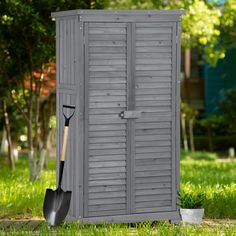 a garden shed with a shovel next to it