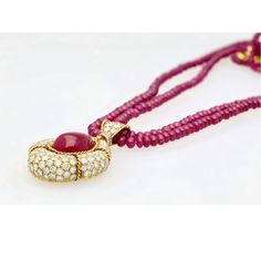 This is part of Chairish’s Fine Jewelry assortment.  This captivating pendant necklace, showcases a mesmerizing 22.41 carat, deep pink ruby cabochon cut, securely set in a classic bezel mounting crafted from 18k yellow gold. The weight of the piece is 27.57 grams. GRS certified, the ruby is surrounded by 144 sparkling diamonds and further complemented by 7 elegant emerald cut diamonds, totalling approximately 13-15 carats. A beaded ruby chain completes this luxurious and unique statement piece. Ruby Chain, Ruby Diamond Pendant, Pink Ruby, Deep Pink, Ruby Diamond, Emerald Cut Diamonds, Diamond Pendant Necklace, Sparkle Diamonds, Emerald Cut