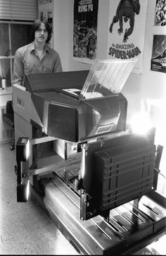 black and white photograph of a man standing in front of a machine