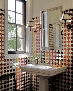 a bathroom with checkered walls and a sink in the middle, next to a window