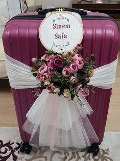 a purple suitcase is adorned with flowers and the words sinem safa on it