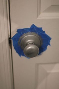 an open door with a blue piece of paper on it's handle and a hole in the front