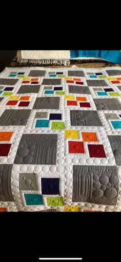 a quilted bed with colorful squares on it