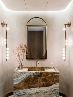 an elegant bathroom with marble counter tops and gold fixtures, along with mirrors on the wall