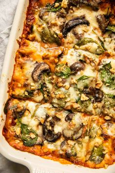 a casserole dish with mushrooms, spinach and cheese