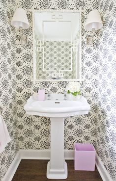 a white pedestal sink sitting under a bathroom mirror