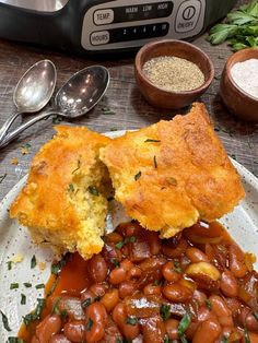 a white plate topped with baked beans and cornbread