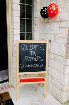 a welcome sign with balloons attached to it