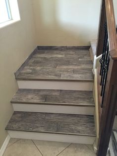 a set of stairs leading up to the second floor in an empty room with tile floors