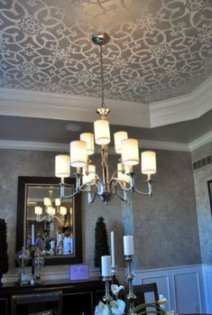 the ceiling is decorated with chandeliers and lights in shades of gray, white and gold