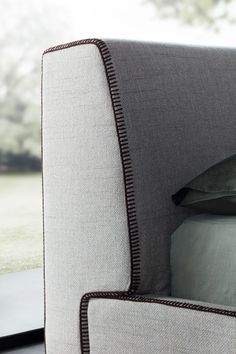 a close up of a bed with a pillow and pillows on it's headboard