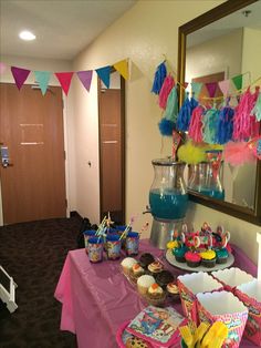 a party table with cupcakes, cake and decorations