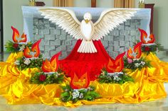 a large white bird sitting on top of a red and yellow table cloth covered in flames