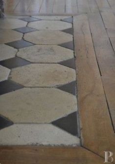 an umbrella is sitting on the floor next to some wood planks and stone tiles