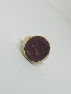 "This is a vintage 18K (high-karat) yellow gold Cameo-design statement ring. Definition of a \"cameo\": a piece of jewelry, typically oval in shape, consisting of a portrait in profile carved in relief on a background of a different color. Material(s): 18K yellow gold + unidentified material (cameo) Total weight: 12.2 grams Flaws (if any): None to mention Marking(s): \"18ct\" (translating to 18K gold) Measurements: The face of the ring measures 17.9 millimeters in height by 5.8 millimeters in wi Classic Yellow Gold Signet Ring With Cabochon, Formal Gold Cabochon Signet Ring, Gold Heirloom Signet Ring With Cabochon, Heirloom Gold Signet Ring With Cabochon, Gift Yellow Gold Cabochon Signet Ring, Classic Brass Jewelry With Cabochon, Classic Engraved Cabochon Ring, Formal Brass Rings, Brass Rings For Formal Occasions