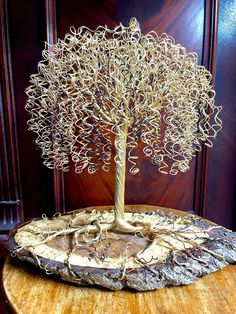 a wire tree sitting on top of a wooden table