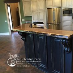 a large kitchen island in the middle of a room with an oven, refrigerator and dishwasher