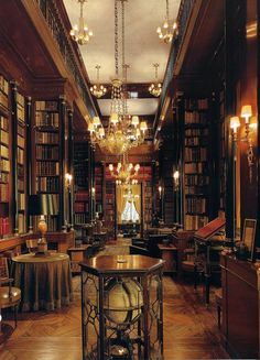 an old library with chandeliers and bookshelves