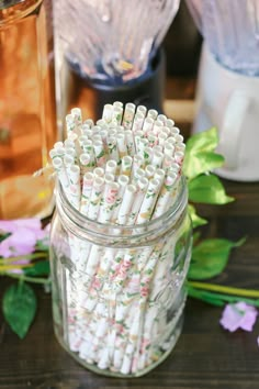 a jar filled with lots of white and pink straws