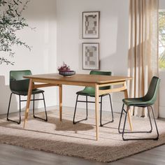 a dining room table with green chairs and a rug on the floor in front of it